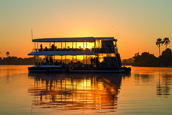 Embark on a mesmerizing river cruise along the enchanting Victoria Falls at sunset. As the golden hues of dusk paint the sky, witness the majestic cascade of water against the backdrop of the African horizon. The scene unfolds in unparalleled beauty, a symphony of colors and tranquility merging to create an unforgettable experience of nature's splendor. Embark on a mesmerizing river cruise along the enchanting Victoria Falls at sunset. As the golden hues of dusk paint the sky, witness the majestic cascade of water against the backdrop of the African horizon. The scene unfolds in unparalleled beauty, a symphony of colors and tranquility merging to create an unforgettable experience of nature's splendor.